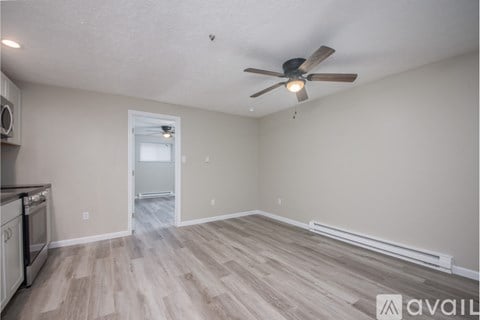 A room with a ceiling fan and wooden flooring.