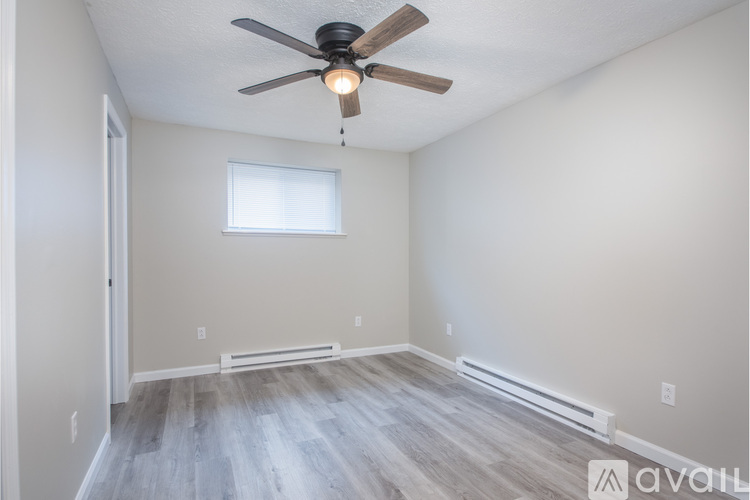 A room with a ceiling fan and a window.