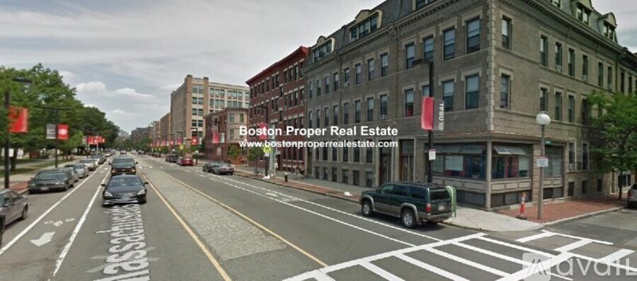 A street view of a city with a car driving on the road.