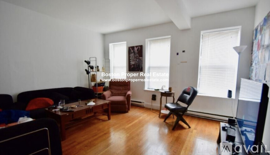 A living room with a couch, chairs, and a coffee table.