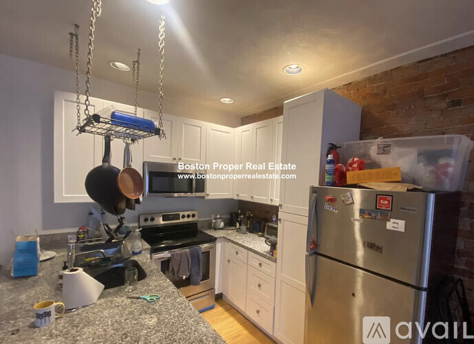 A kitchen with a stove top oven and a refrigerator.