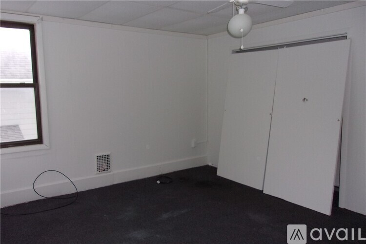 A room with a fan, window, and a door.