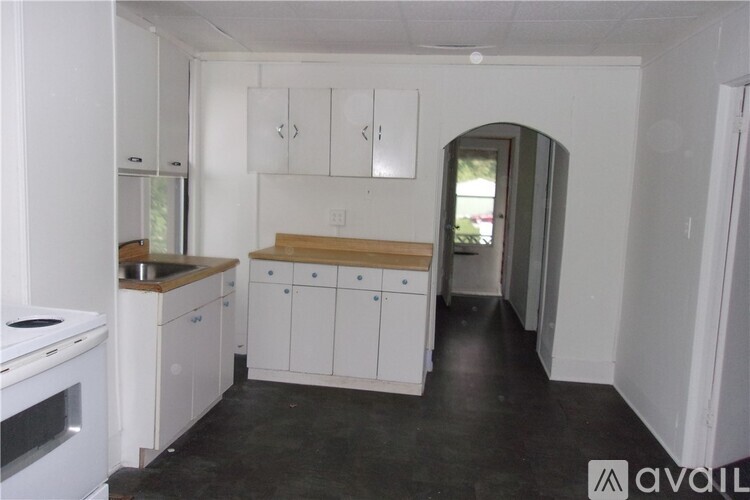 A kitchen with white cabinets and a black floor.