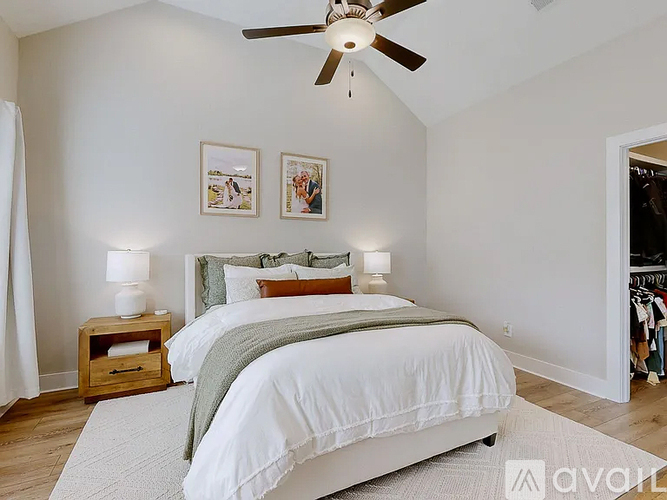 A bedroom with a large bed and a ceiling fan.