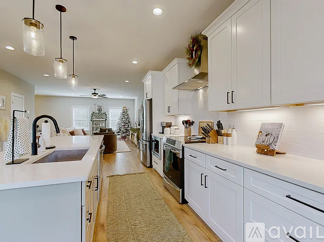 A kitchen with white cabinets and a wreath on the wall.