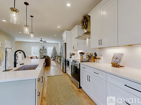 A kitchen with white cabinets and a wreath on the wall.