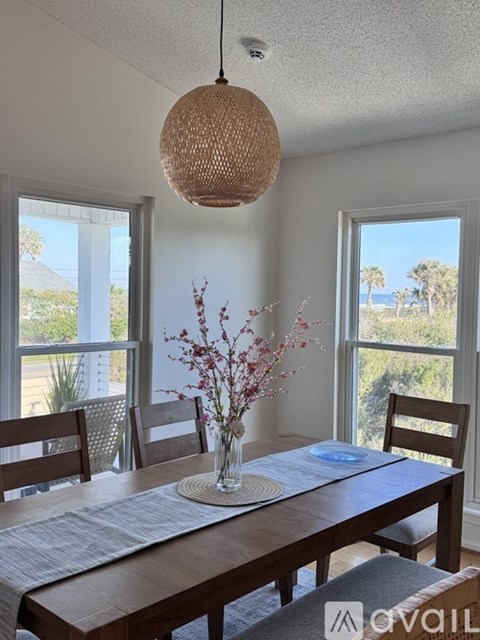 A dining room with a wooden table and chairs.