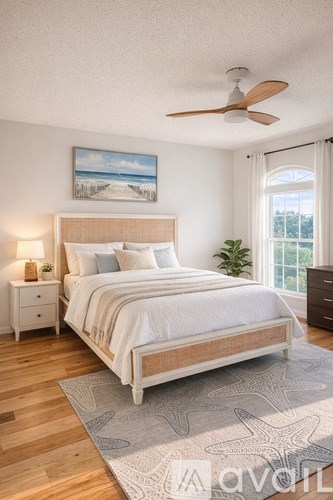A bedroom with a large bed and a painting of a beach scene on the wall.