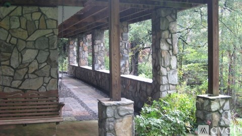 A wooden bench sits in front of a stone wall.
