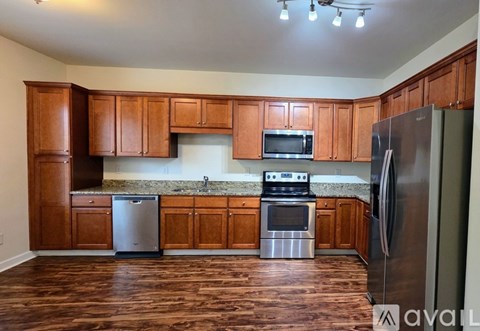 A kitchen with wooden cabinets and stainless steel appliances.