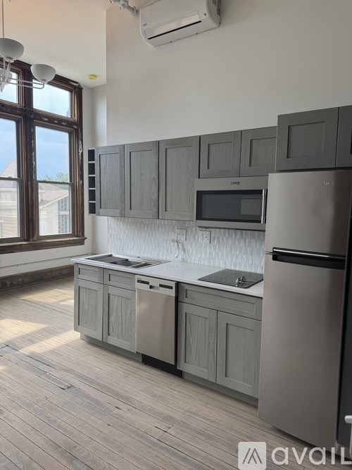 A kitchen with wooden cabinets and a stainless steel refrigerator.