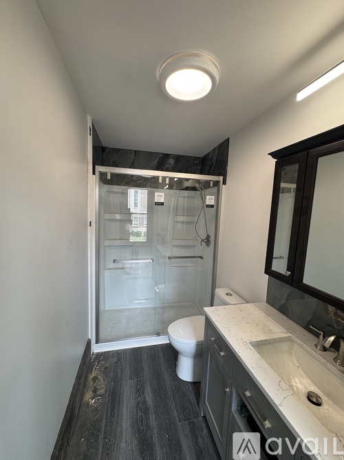 A bathroom with a toilet, sink, and shower.