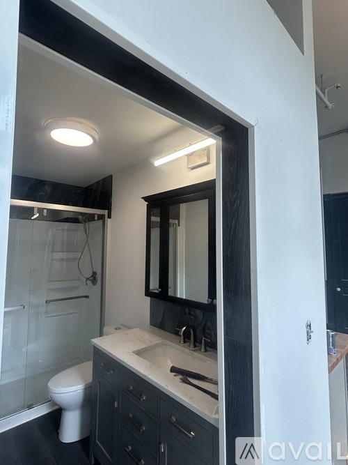 A bathroom with a toilet, sink, and mirror.