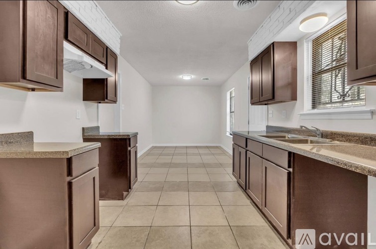 A kitchen with brown cabinets and a countertop is available for rent.
