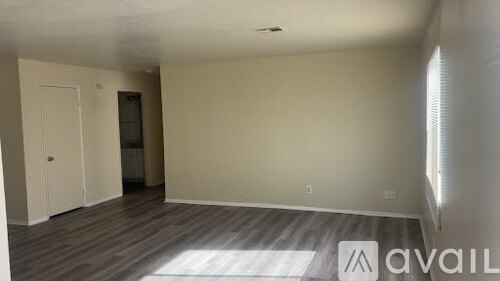 A room with wooden flooring and a white door.