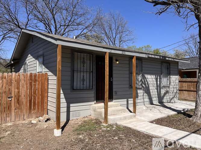 A grey house with a brown fence in front.