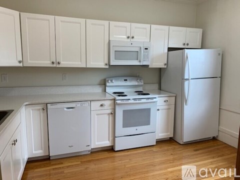 A kitchen with white appliances and cabinets.