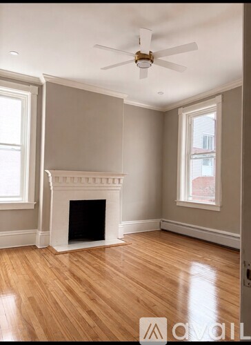 A living room with a fireplace and a ceiling fan.
