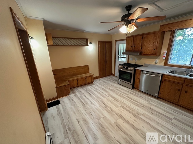 A kitchen with wooden floors and a ceiling fan.
