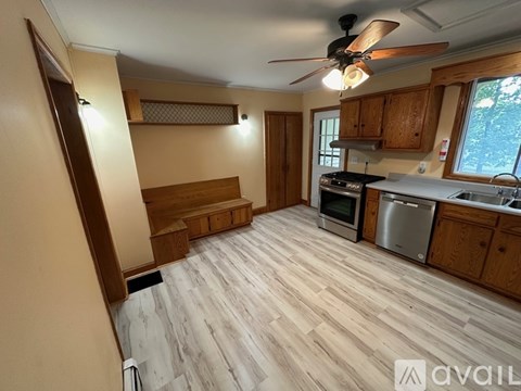 A kitchen with wooden floors and a ceiling fan.