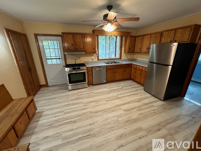 A kitchen with wooden cabinets and a refrigerator.
