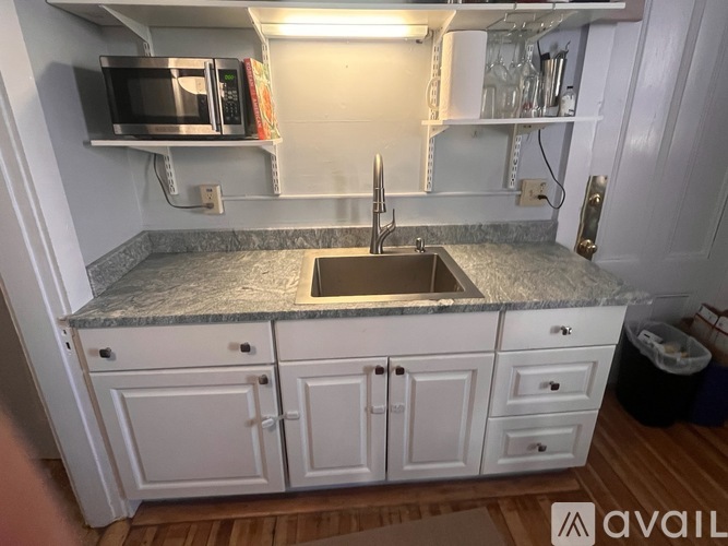 A kitchen with white cabinets and a granite countertop.