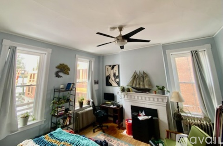 A living room with a fireplace and a ceiling fan.