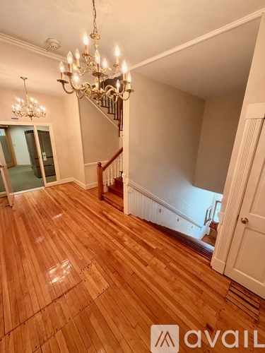 A room with wooden floors and a chandelier.