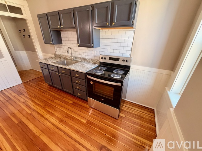 A kitchen with a stove top oven and a sink.