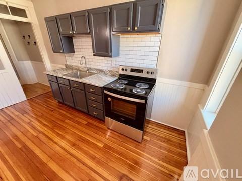 A kitchen with a stove top oven and a sink.