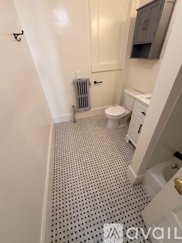 A bathroom with a toilet, sink, and a radiator.