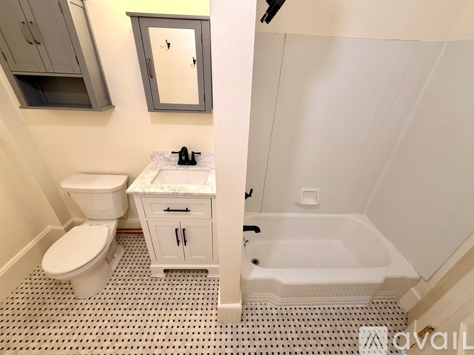 A bathroom with a toilet, sink, and bathtub.