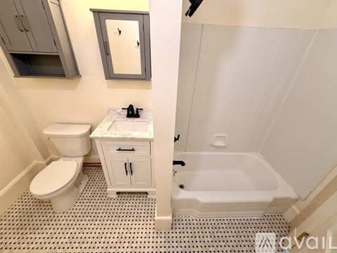 A bathroom with a toilet, sink, and bathtub.
