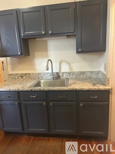 A kitchen with dark cabinets and a granite countertop.