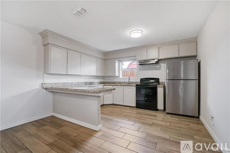 A kitchen with a granite countertop and stainless steel appliances.