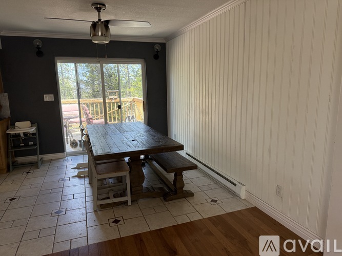 A dining room with a wooden table and chairs.