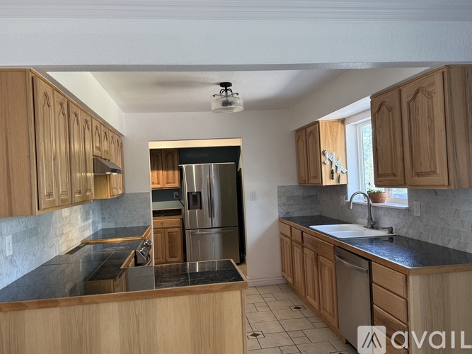 A kitchen with wooden cabinets and a black countertop.