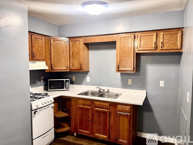 A kitchen with wooden cabinets and a white countertop.