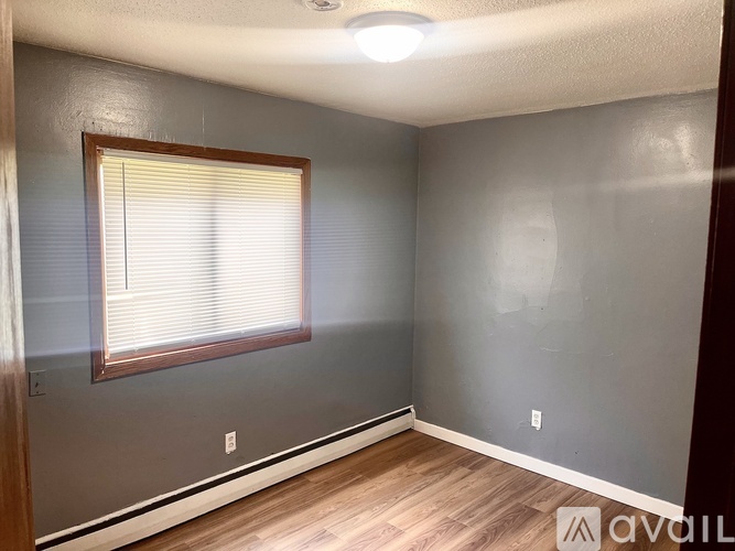A room with a window and wooden flooring.