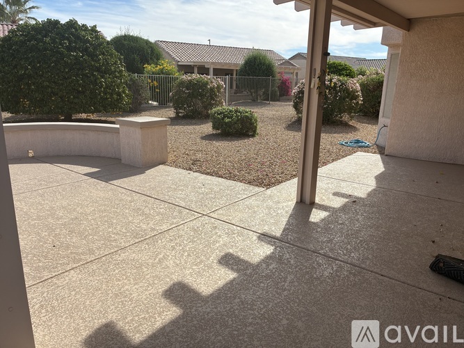A patio area with a concrete floor and a small garden.