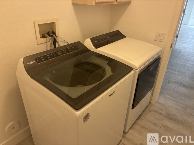 A white front loading dishwasher with a black top is in a kitchen.