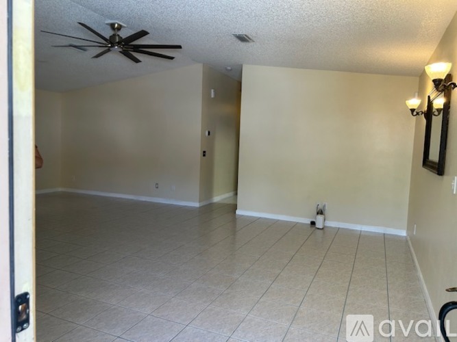 A room with a ceiling fan and tiled flooring.