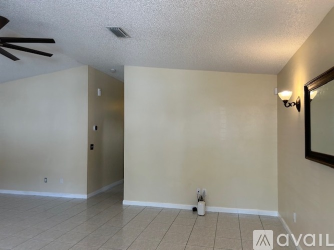 A room with a ceiling fan and a mirror on the wall.