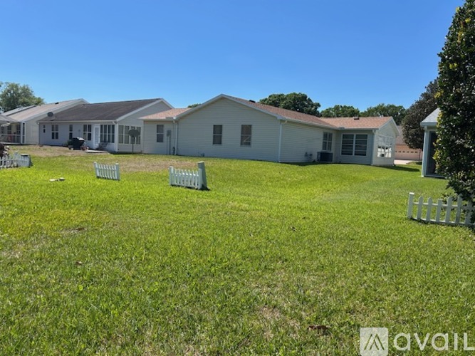 A grassy field with a house and a sign that says "available".