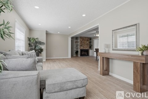 A living room with a grey couch and a wooden table.