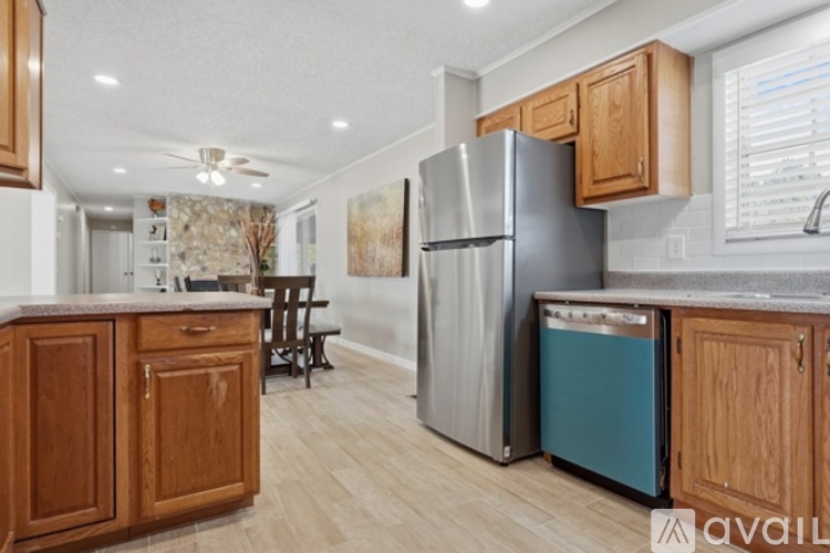 A kitchen with wooden cabinets and a stainless steel refrigerator.