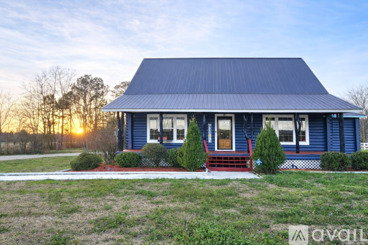 A blue house with a red door and a porch.