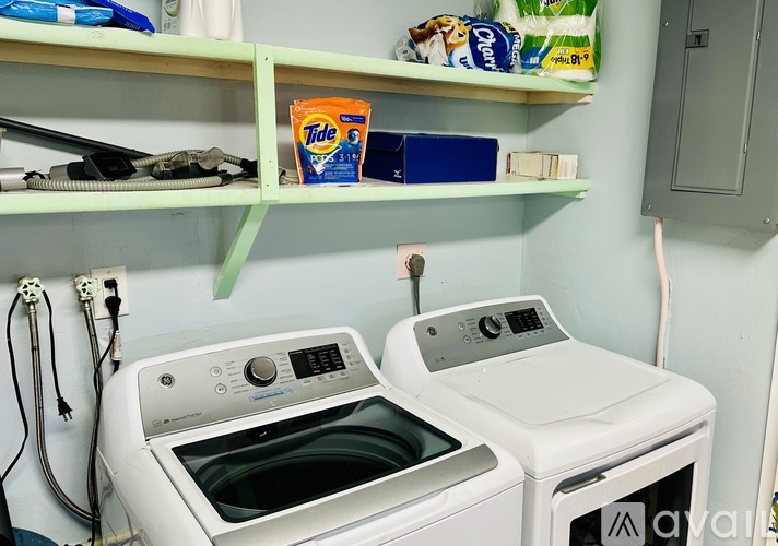 Two front loading washing machines in a small laundry room.