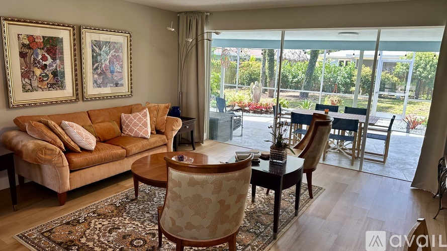 A living room with a couch, chairs, and a rug.