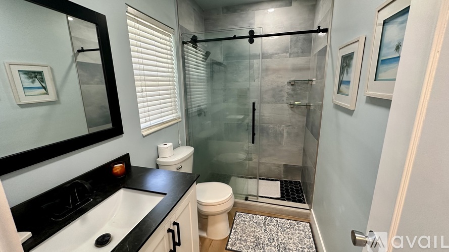 A bathroom with a toilet, sink, and shower.